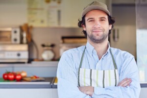 Proud small business owner standing in front of his business where he makes and sells takeaway food