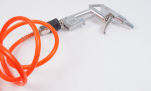 An air blow gun with an orange coiled hose on a white background